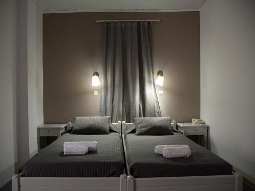 a bedroom with two beds and two lights on the wall at Olive Press Hotel in Mithymna