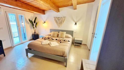a bedroom with a large bed in a room with windows at Flamingo Suites in Marina di Camerota