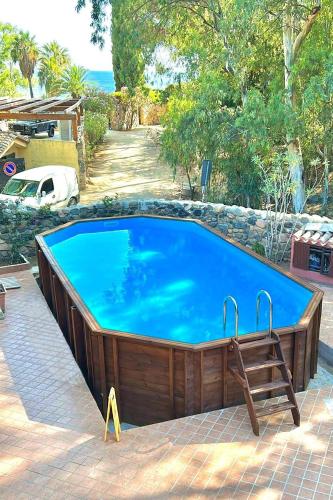 a large swimming pool with a bench around it at Villa La Petite Etoile in Torre delle Stelle