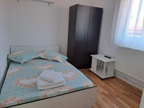 a bedroom with a bed and a black cabinet at Vila Emy Constanta in Constanţa