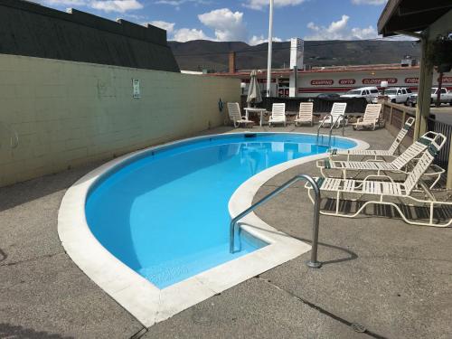 ein großer Pool mit Stühlen und ein Baseballstadion in der Unterkunft Cedars Inn Lewiston in Lewiston