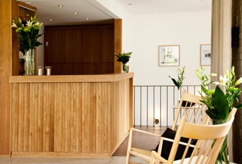 a lobby with a bar with two chairs and flowers at Ekebacken Hotell & Konferens in Markaryd