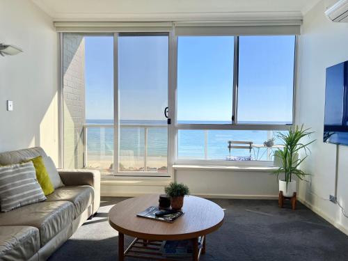 グレネルグにあるOceanview escape in beachside Glenelgのソファとテーブルのあるリビングルーム