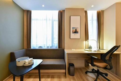 a living room with a desk and a chair at Atour Hotel Dalian Lvshunkou in Dalian