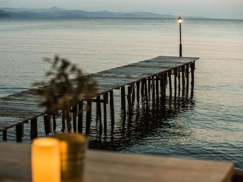 a dock with a light on top of the water at Olive Press Hotel in Mithymna
