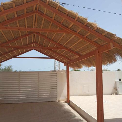 a pavilion with a wooden roof on a building at Villa sweet Djerba A 5km de la plage et de centre Midoun in Arkou