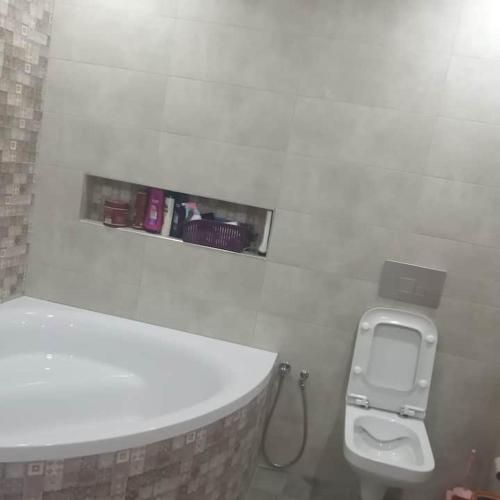 a bathroom with a toilet with a soap dispenser on the wall at Villa sweet Djerba A 5km de la plage et de centre Midoun in Arkou