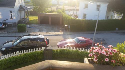 two cars parked in a yard with a fence at Rundvejen Guest House in Aalborg