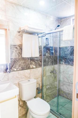 a bathroom with a toilet and a glass shower at Ale Apartments Hotel in Antalya