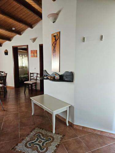 a living room with a table on a wall at Villa Paola Pantalica in Cassaro