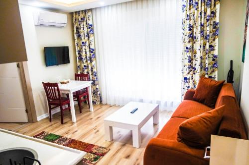 شقق ألي الفندقية في أنطاليا: غرفة معيشة مع أريكة وطاولة
