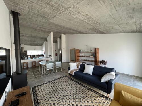 a living room with a blue couch and a kitchen at Casas de Sao Miguel in Évora