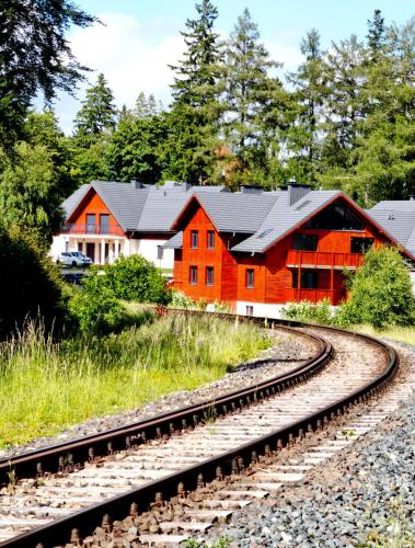 a train track in front of a red building at Apartament Górski Widok in Szklarska Poręba
