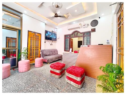 AyodhyaHOTEL SHREE MATESHWARI # PALACE Near Ramjanambhoomi - Shri Hanuman Garhi Mandir 800M & Ayodhya Dham Junction Railway Station - Fully Air Conditioning Rooms - Free Wifi & Parking Facilities - Excellent Customer Service的客厅里摆放着粉色凳子和椅子