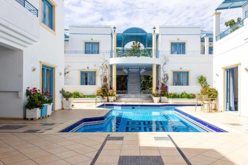 a villa with a swimming pool in front of a building at Blue Calm in Daratso