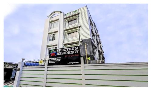 グワーハーティーにあるSpectrum Residency Best Hotel In Guwahatiの看板の付いた背の高い白い建物