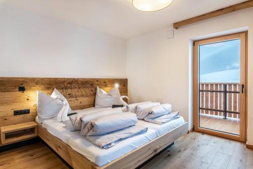 a bedroom with a large bed with white pillows at Planerhof Apartment Lilie in Funes