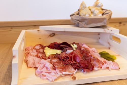 a cutting board with meat and other foods on it at Planerhof Apartment Lilie in Funes