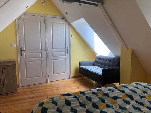 Un dormitorio con una cama y un sofá en un ático. en Gîte le Laurier, en Saint-James