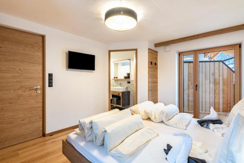 a living room with a white couch with pillows at Planerhof Apartment Alpenrose in Funes