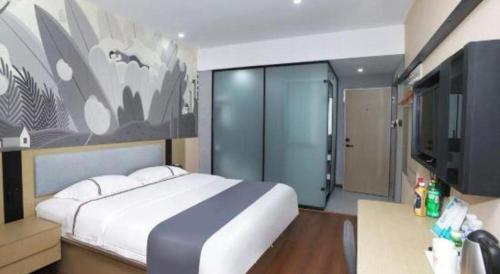 a bedroom with a large bed and a tv at Thank Inn Hotel He'nan Xinxiang Changyuan Bo'ai Road in Changyuan