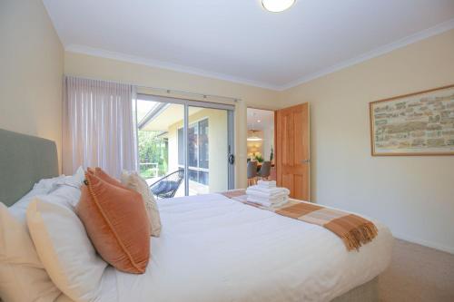 a bedroom with a large white bed and a window at On The Trail in Bright