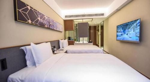 a hotel room with two beds and a tv at AURAYA BY SUNING NANJING XUZHUANG in Nanjing