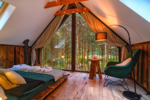 a bedroom with a bed and a large window at Dziupla House in Czarna