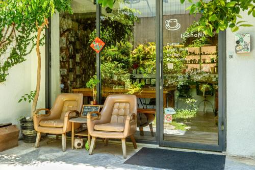 two chairs and a table in front of a store at IsShoNi house in Tainan