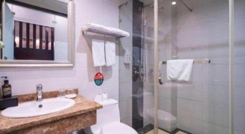 a bathroom with a toilet and a sink and a shower at GreenTree Inn Wuxi Xinwu District Meicun Town Taibo Avenue in Wuxi