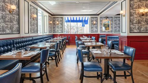 a restaurant with wooden tables and blue chairs at Willard InterContinental Washington by IHG in Washington