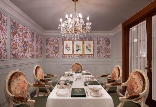 a dining room with a table and chairs and a chandelier at Willard InterContinental Washington by IHG in Washington