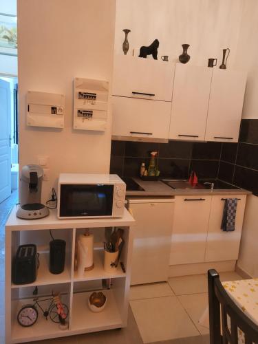 une cuisine avec des armoires blanches et un micro-ondes dans l'établissement Joli nid douillet, aux Sorinières