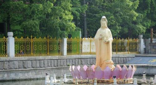 a statue of a woman in front of a fence at 7 Days Inn Qingdao Liaoyang West Road Xinye Plaza Metro Station in Qingdao