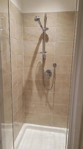 a shower with a glass door and a sink at Quattro Stelle al Porto Guest House in Civitavecchia