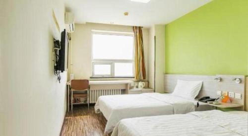 a hotel room with two beds and a window at 7 Days Inn Tianjin Binhai New District Yujiabao Metro Station in Binhai