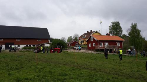 a group of people standing in a field near a red house at Älgbergets Bed & Breakfast in Ucklum