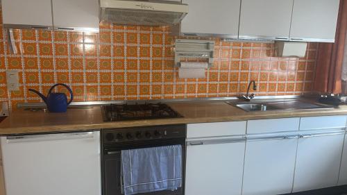 a kitchen with white cabinets and a stove top oven at Ferienwohnung in Wirges in Wirges