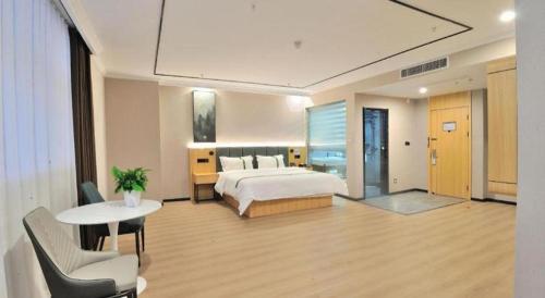 a hotel room with a bed and a table and chairs at GreenTree Inn Suzhou Shihu Suli Road Express Hotel in Suzhou