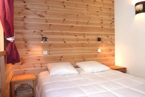 - une chambre avec un mur en bois et un lit dans l'établissement Les Cabasses 8 - Housing in a village house, à Villar-dʼArêne