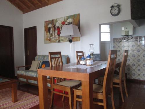 comedor con mesa, sillas y sofá en Quintinha da Chinela, en Porto Judeu