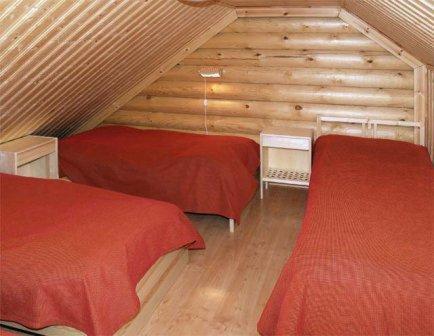 a room with two beds in a wooden cabin at Serena Villas in Espoo