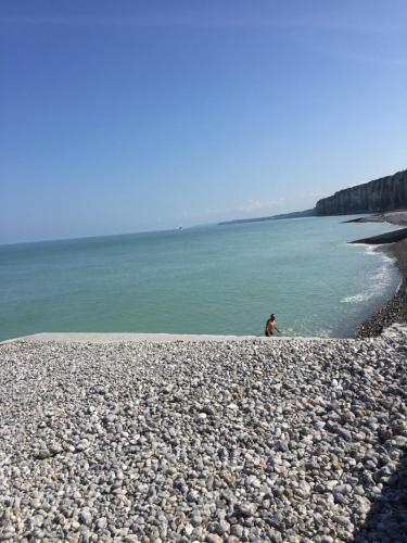 a person sitting on a rocky beach near the water at La grange du clos in Angiens