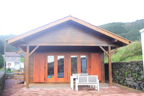 a gazebo with a picnic table and a bench at Casa dos Manos in Furnas