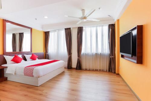a bedroom with a bed and a flat screen tv at Dancenter Super Cowboy Hotel Melaka in Melaka