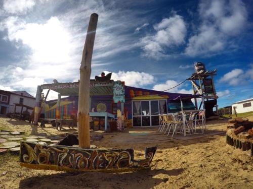 a building with a wooden pole in front of it at Lobo Hostel Bar in Cabo Polonio