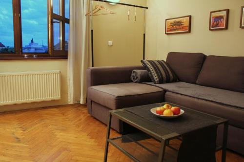 una sala de estar con sofá y un bol de fruta en una mesa en 4Party, en Cracovia