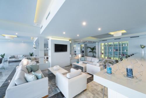 een woonkamer met witte meubels en een televisie bij Contessa Hotel in Argassi