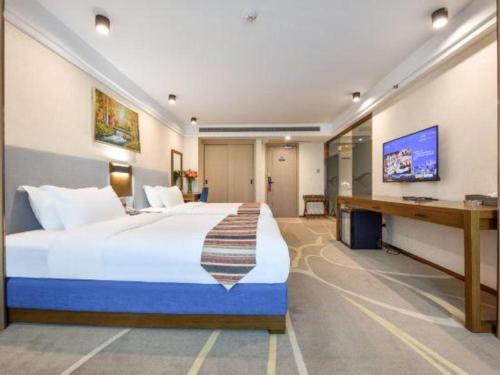 a hotel room with a large bed and a desk at Dalian Bohai Pearl Hotel in Dalian