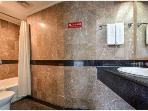 a bathroom with a sink and a toilet at Dalian Bohai Pearl Hotel in Dalian